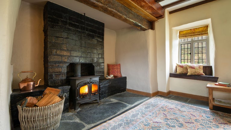 The inglenook fireplace with woodburner in the sitting room of Fron Dirion, Powys